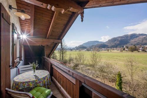 uma varanda com uma mesa e cadeiras e vista para um campo em Ferienwohnung Gerstner em Oberaudorf