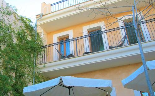 a building with an umbrella in front of a balcony at Boutique Hotel Petit Sant Miquel in Calonge