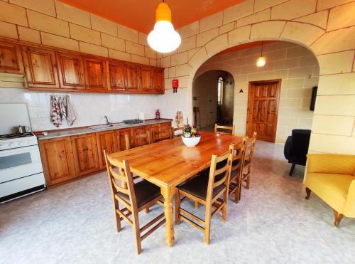 - une cuisine avec une table et des chaises en bois dans l'établissement Wilga Summit Apartment A, à Qala