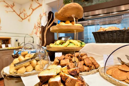 a table with three baskets of bread and pastries at Hotel Resort & Spa Baia Caddinas in Golfo Aranci