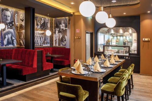 a dining room with a long table and a red couch at Nordhäuser Fürstenhof & TinySky-Resort in Nordhausen