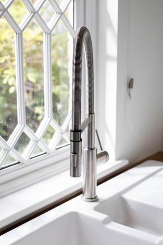 a sink with a faucet next to a window at Fullers Hill Cottages in Little Grandsen