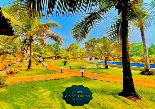 een park met palmbomen en een zwembad bij Coco Teros Resort in Mandrem