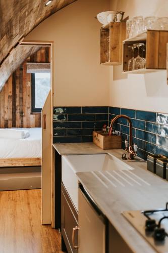 a kitchen with a sink and a bed in a room at Doxford Farm Camping in Alnwick