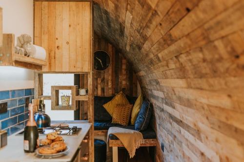 a kitchen with a wooden wall in a tiny house at Doxford Farm Camping in Alnwick