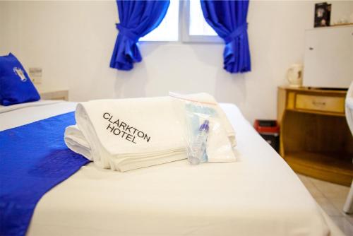 a hotel room with a bed with blue curtains at Clarkton Hotel Apartment in Angeles