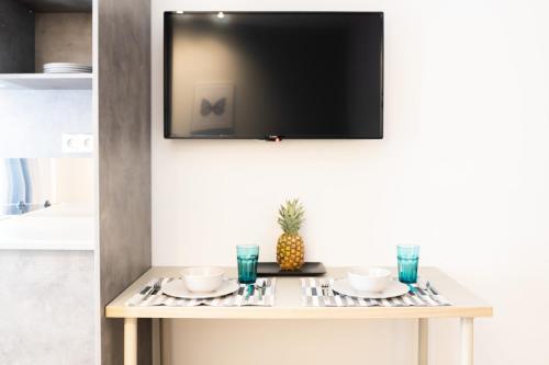 a table with two plates and a television on a wall at A17 Modern & Cosy 2R flat up to 4ppl near Parthenon in Athens