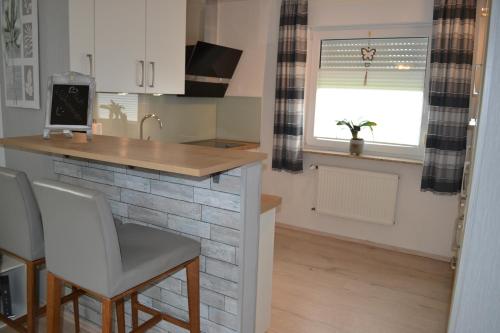 a kitchen with a counter and a bar in a room at Ferienhaus am Wasser (Knockster Tief) in Hinte