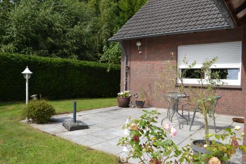 a brick house with a patio in the yard at Ferienhaus am Wasser (Knockster Tief) in Hinte