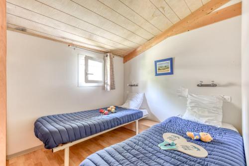 1 dormitorio con 2 camas y ventana en Camping maeva Escapades Le Domaine du Cèdre, en Rivières