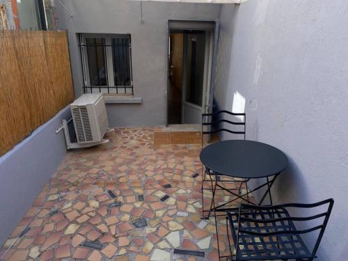 uma varanda com uma mesa e cadeiras num pátio em Superbe Appartement climatisé avec Patio em Montpellier