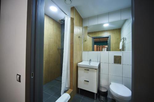 a small bathroom with a toilet and a sink at Urban Hotel in Omsk