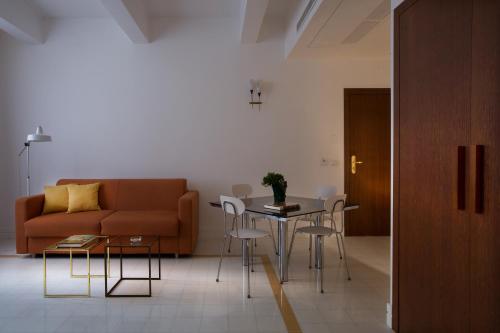 salon z kanapą, stołem i krzesłami w obiekcie Corso Novara 5 Design Apartments w mieście Neapol