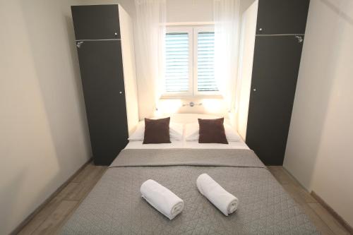 a bedroom with two beds with pillows and a window at Apartments Viola in Tučepi