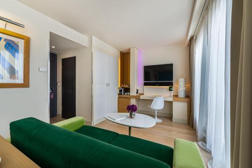 a living room with a green couch and a table at N’vY Manotel in Geneva