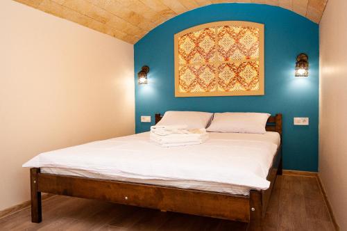 uma cama num quarto com uma parede azul em Suites on Chaikovskogo em Odessa