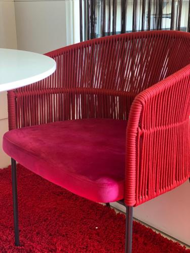 a red chair sitting next to a white table at Gran Paradiso Hotel Spa in San Giovanni Rotondo