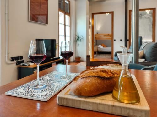 zwei Gläser Wein und ein Laib Brot auf dem Tisch. in der Unterkunft Les Voltes in Barbará