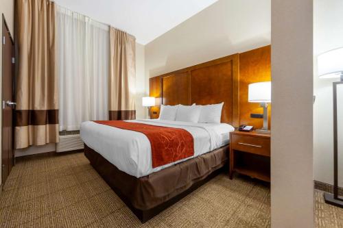 a hotel room with a large bed and a desk at Comfort Suites in La Vista