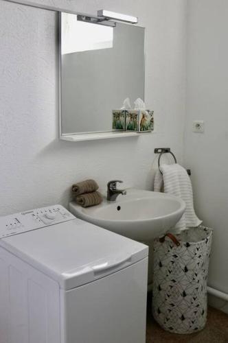 une salle de bain blanche avec un lavabo et un miroir dans l'établissement Maison Spacieuse à Boulieu, à Courtenay