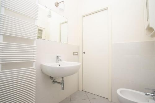 a white bathroom with a sink and a mirror at N172 - Numana, meraviglioso trilocale con giardino in Sirolo