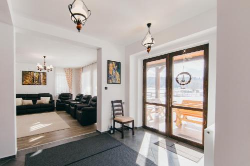 a living room with a couch and a table at Cinege Vendeghaz/Casa de oaspeți Pițigoi in Izvoare