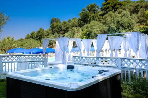 a hot tub in a yard with white curtains at Hotel & Spa Relais Freedom Club in Massa Lubrense