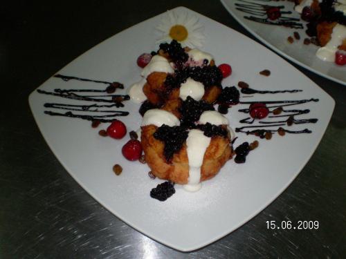 a white plate with a dessert with blackberries and whipped cream at Motel Davios in Târgu Jiu