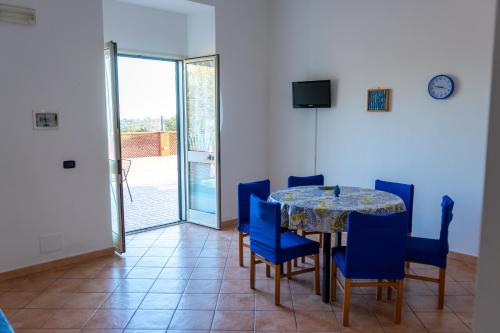 une salle à manger avec une table et des chaises bleues dans l'établissement Camia Etna House, à Piedimonte Etneo