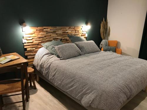 a bedroom with a large bed with a wooden headboard at Cale 32 - Chambres d'hôtes in Saint-Jean-de-Monts
