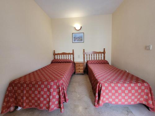 two beds sitting next to each other in a room at Torres Gardens-Fincas Benidorm in Benidorm