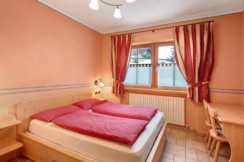 een slaapkamer met een bed, een tafel en een raam bij Chalet Betty Appartamento Pec in Livigno