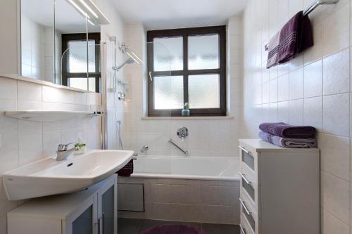 a white bathroom with a sink and a bath tub at Fewo Christina in Garmisch-Partenkirchen