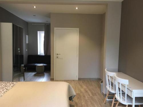 a bedroom with a bed and a desk and a door at Le Jardin du Thé Bord de la Meuse in Namur