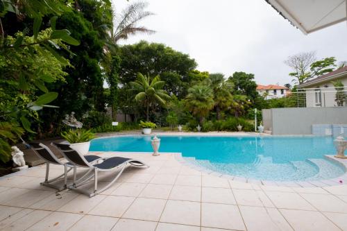 a swimming pool with chairs next to a house at 39 on Church in Port Elizabeth