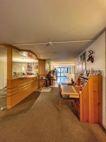 a living room with a desk and a kitchen at Hotel Hecht in Rheineck