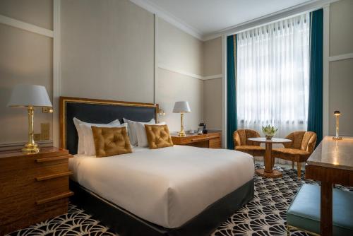 a hotel room with a large bed and a large window at Maison Albar Hotels Le Monumental Palace in Porto