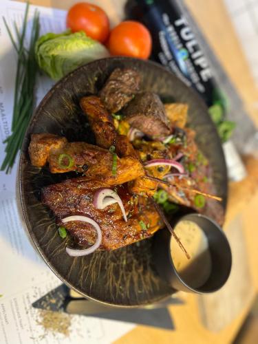 a plate of food with meat and vegetables on a table at Le Bistro in Valkenburg