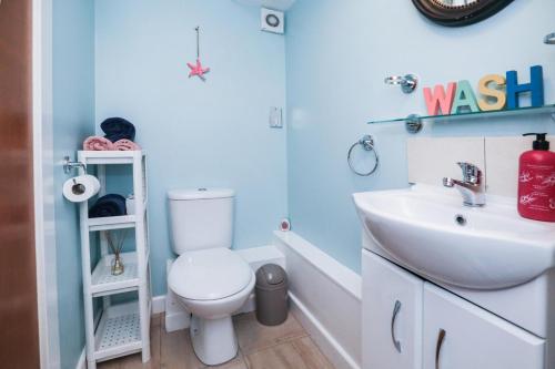 uma casa de banho com um WC branco e um lavatório. em Beautiful 1-Bed Apartment near Castle em Edinburgo
