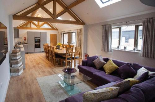 a living room with a purple couch and a table at Fullers Hill Cottages in Little Grandsen