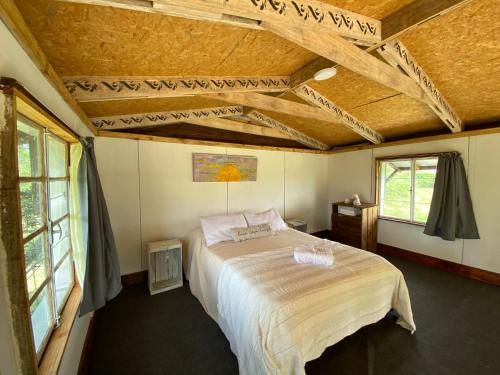 a bedroom with a large bed in a room with windows at Uy - Cabaña de ESTILO, entorno Natural ùnico in Mercedes