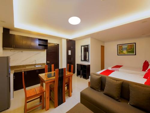ein Schlafzimmer mit einem Bett, einem Sofa und einem Schreibtisch in der Unterkunft OYO 848 Dona Aurora Condotel in Manila