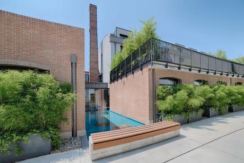 a swimming pool next to a brick building with a bench at NH Collection Murano Villa in Murano