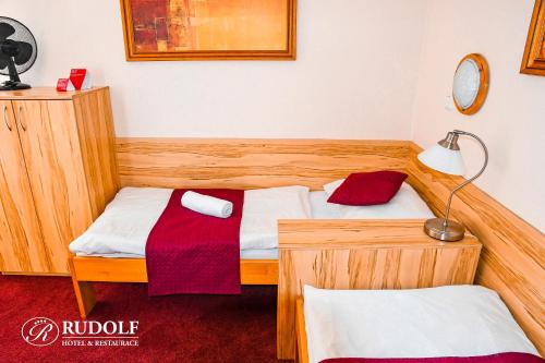 a bedroom with a wooden bed with a lamp and a bedskirts at Hotel Rudolf in Havířov