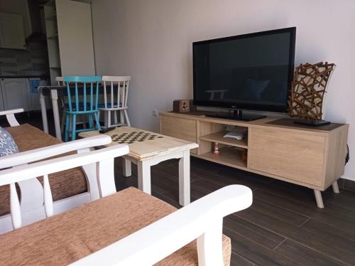 a living room with a flat screen tv on a entertainment center at Buena Fuerte Apartamentos Mari Giuli in Tarajalejo