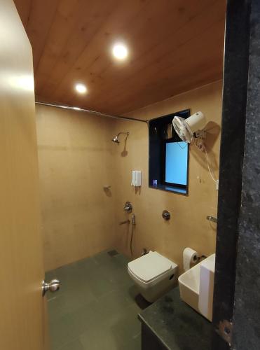 bagno con servizi igienici, lavandino e finestra di Windsongs A Premium Seaview Tropical Village a Ratnagiri
