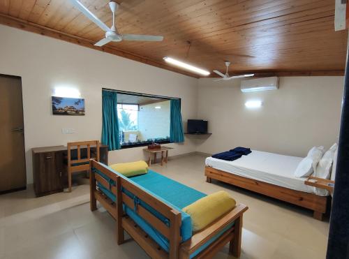 1 dormitorio con 2 camas y ventana en Windsongs A Premium Seaview Tropical Village en Ratnagiri