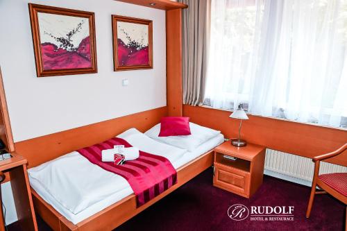 a bedroom with two beds and a table with a lamp at Hotel Rudolf in Havířov