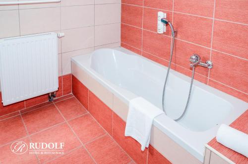 a bathroom with a bath tub and a shower at Hotel Rudolf in Havířov