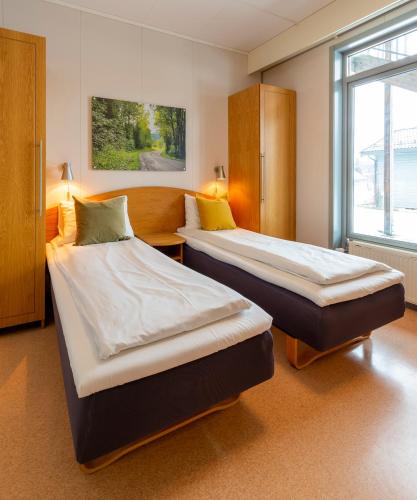 ein Schlafzimmer mit zwei Betten und einem Fenster in der Unterkunft Vikingskipet Hotell in Hamar